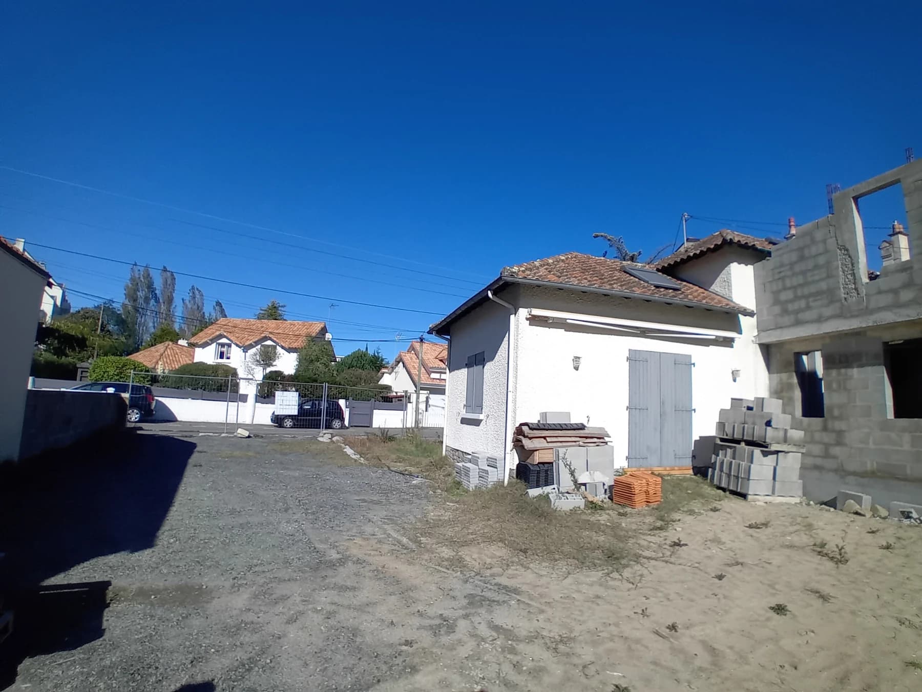 Vue d’ensemble du terrain, de la maison existante et de l’extension en chantier à La Baule.