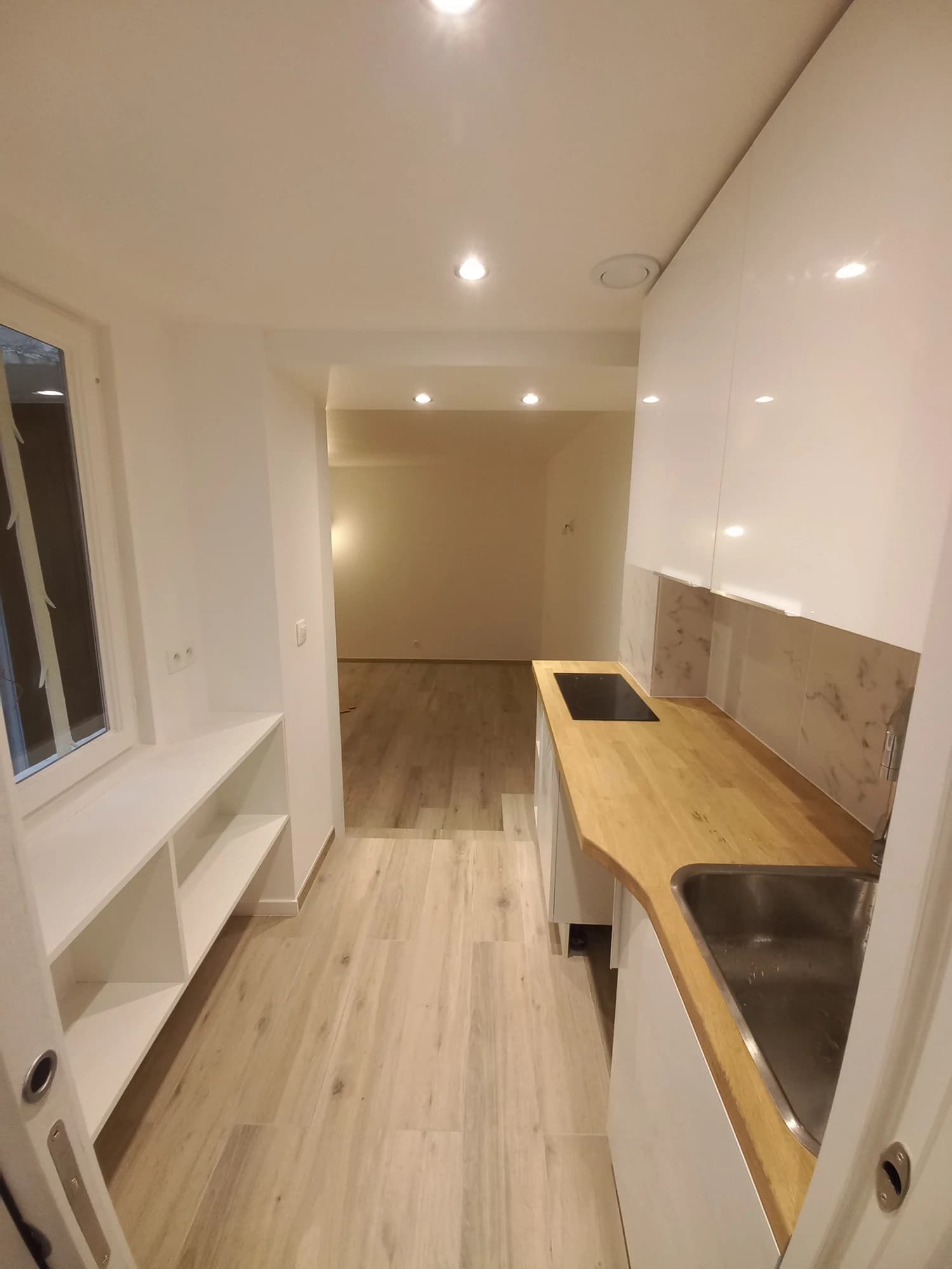 Vue depuis la cuisine vers la pièce principale de l’appartement parisien.