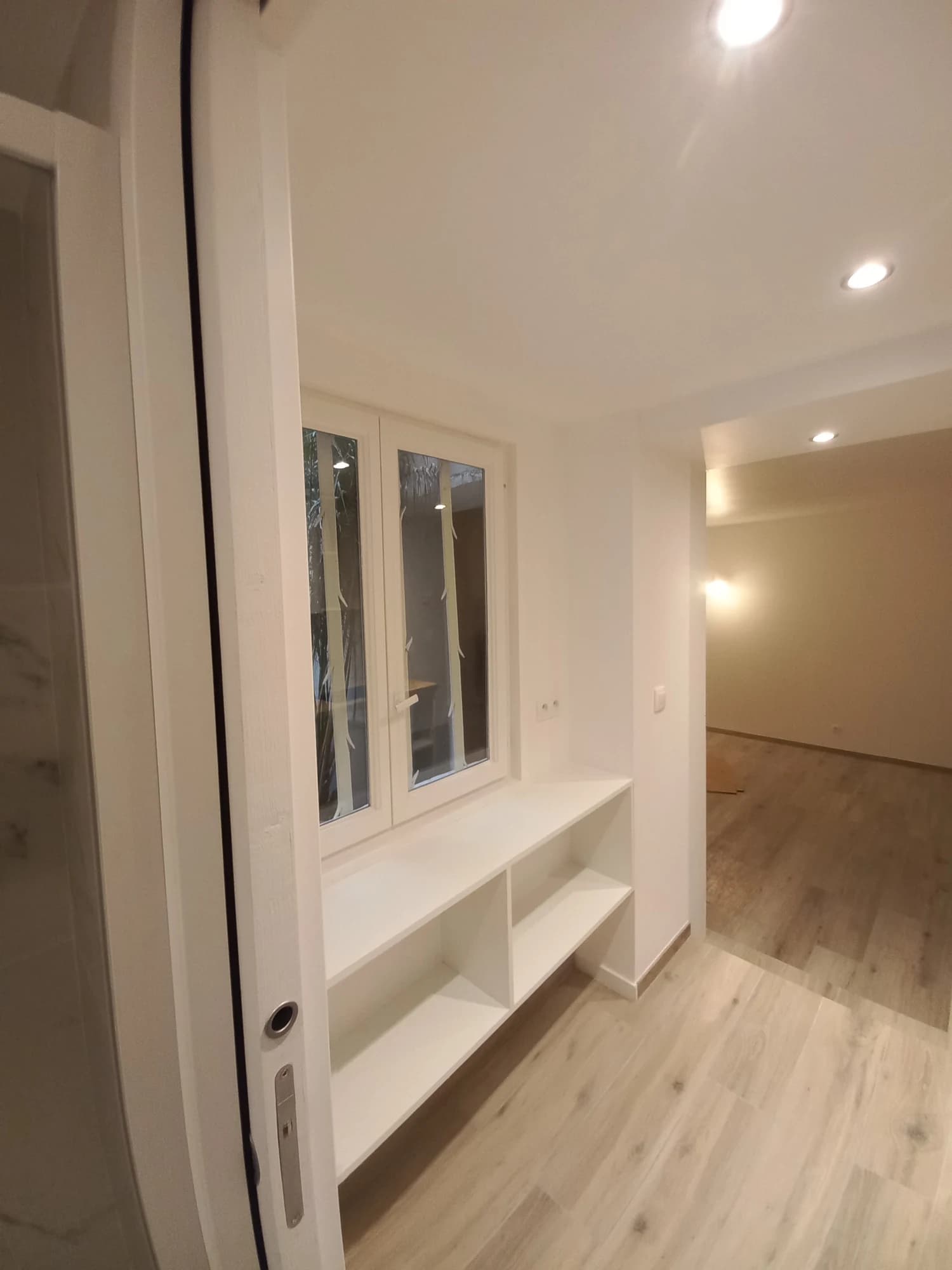 Rangements bas sous la fenêtre de l’appartement parisien, à côté de la cuisine.