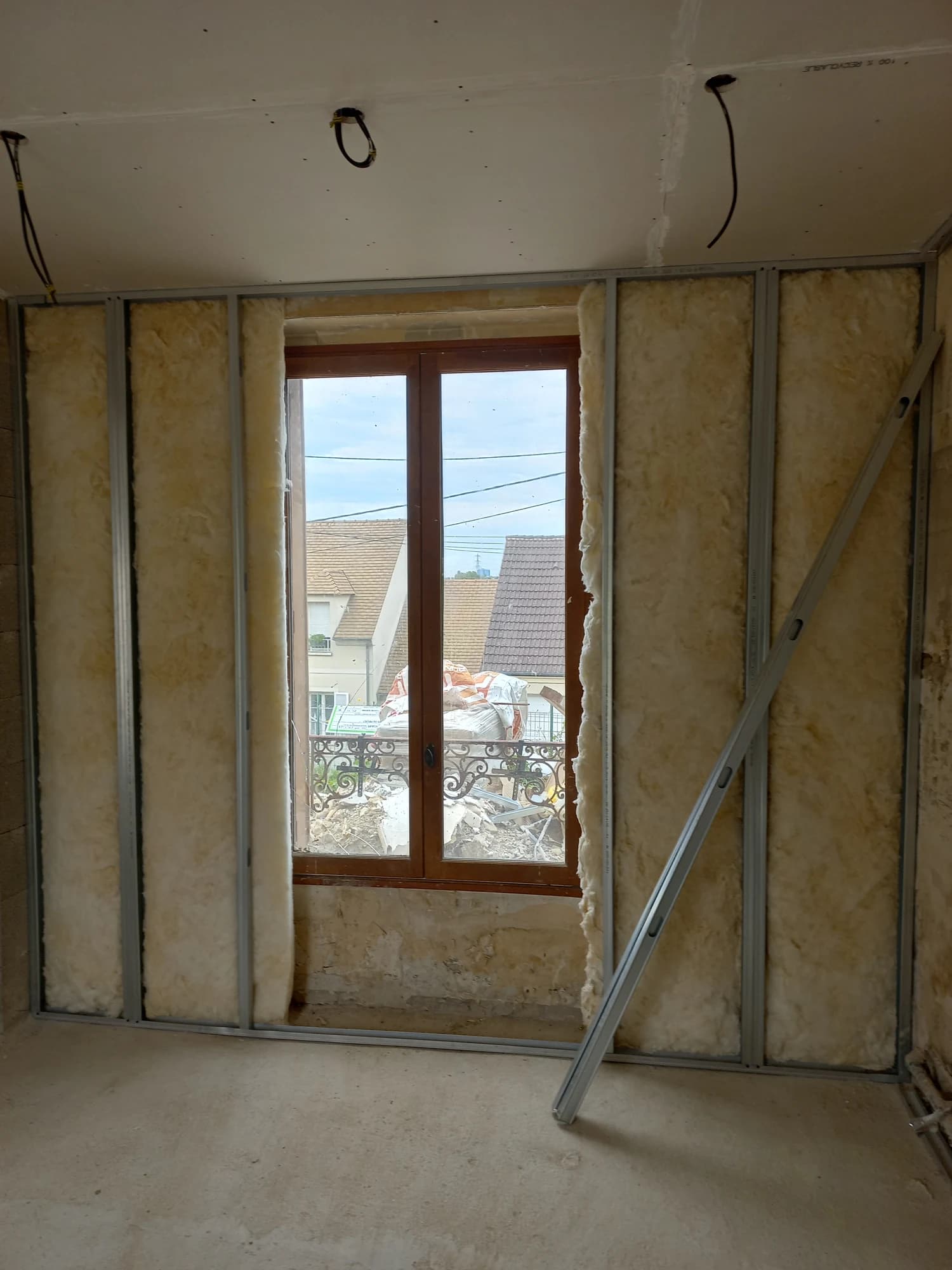 Isolation et ossature des doublages autour d’une fenêtre de la maison à Pontoise.
