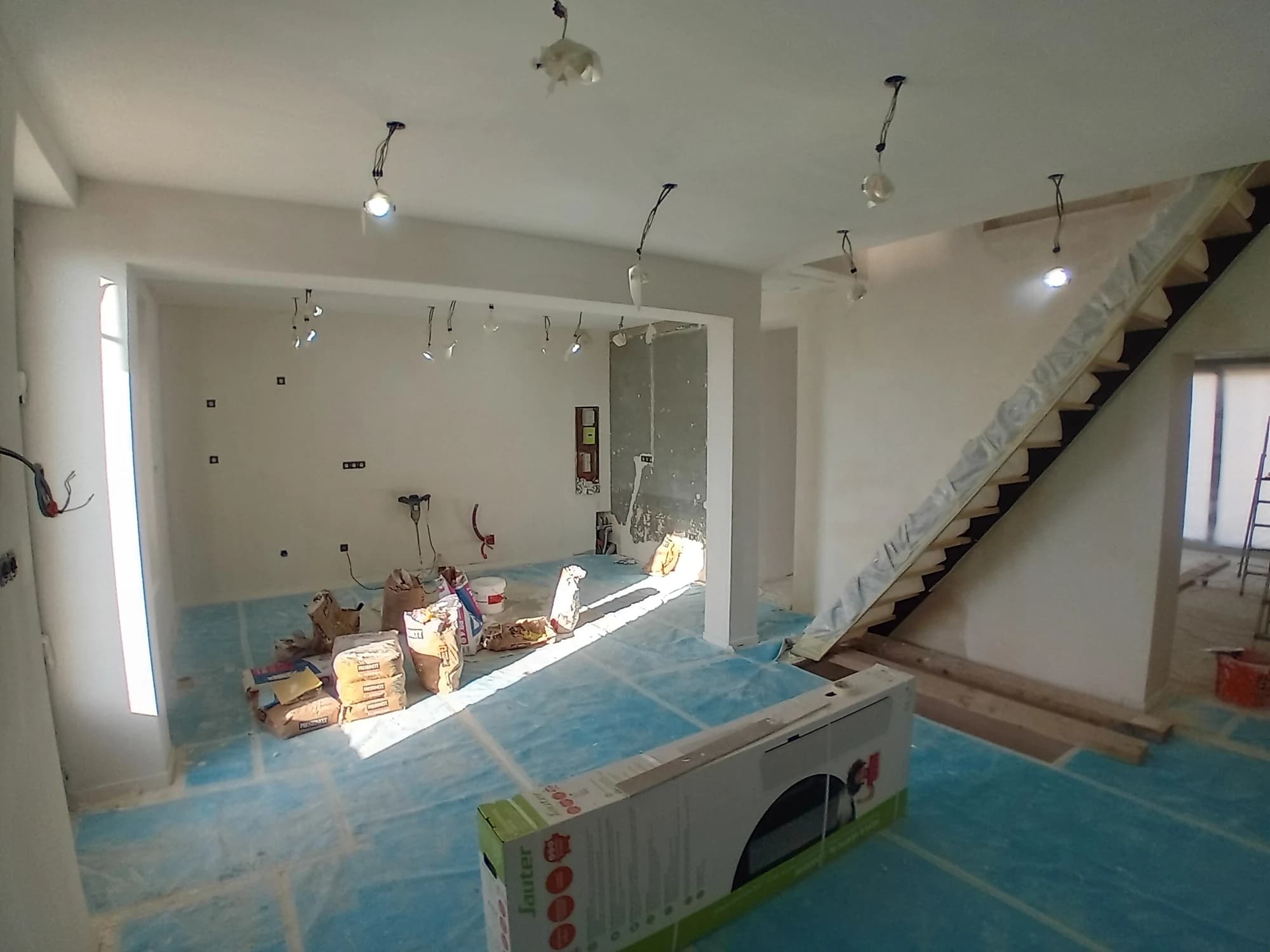 Volume intérieur de la maison à Pontoise en travaux, avec escalier et sols protégés.