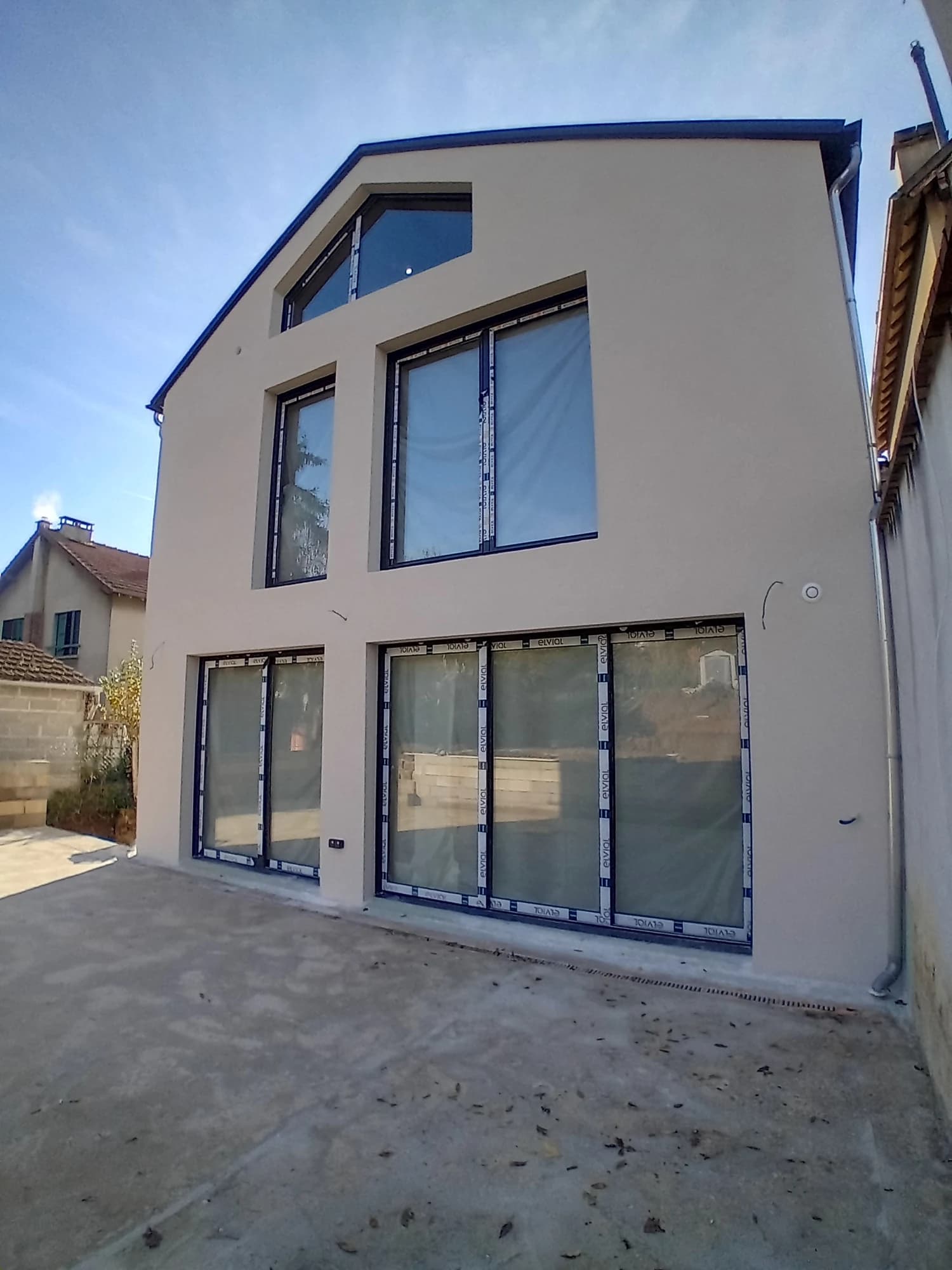 Façade de l’extension à Pontoise, avec de grandes baies sur plusieurs niveaux.