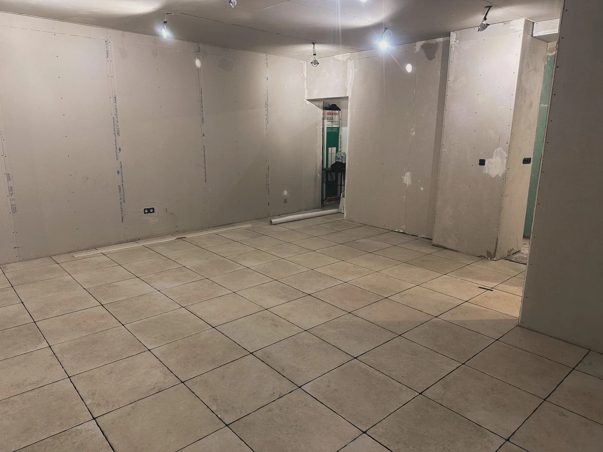 Pièce à Pontoise pendant la rénovation intérieure, avec sol carrelé et parois en cours de finition.