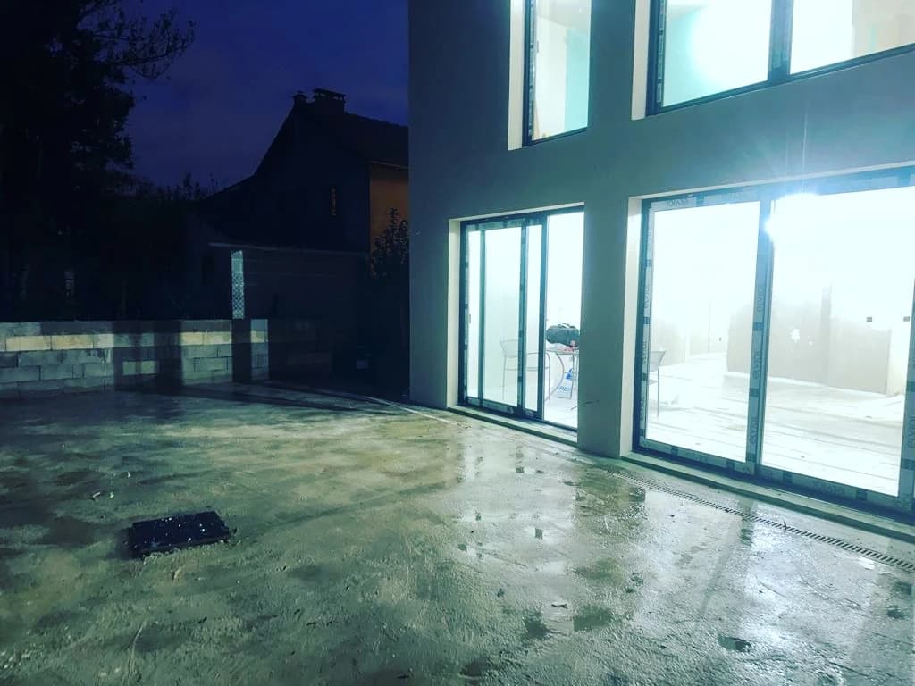 Baies éclairées de l’extension à Pontoise et terrasse extérieure photographiées de nuit.