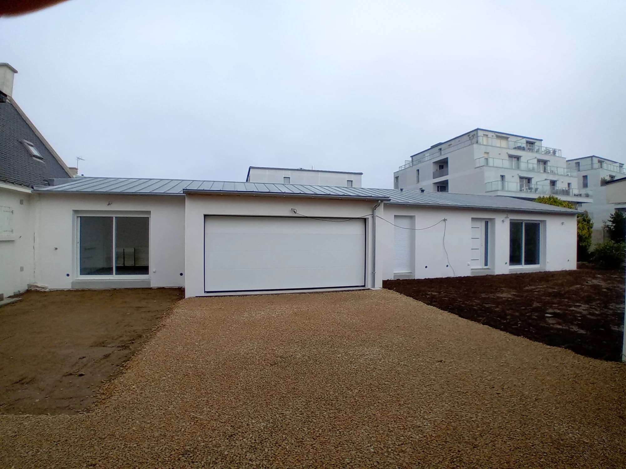 Vue d’ensemble de l’extension à Quiberon, avec façades blanches et ouvertures sur les espaces extérieurs.