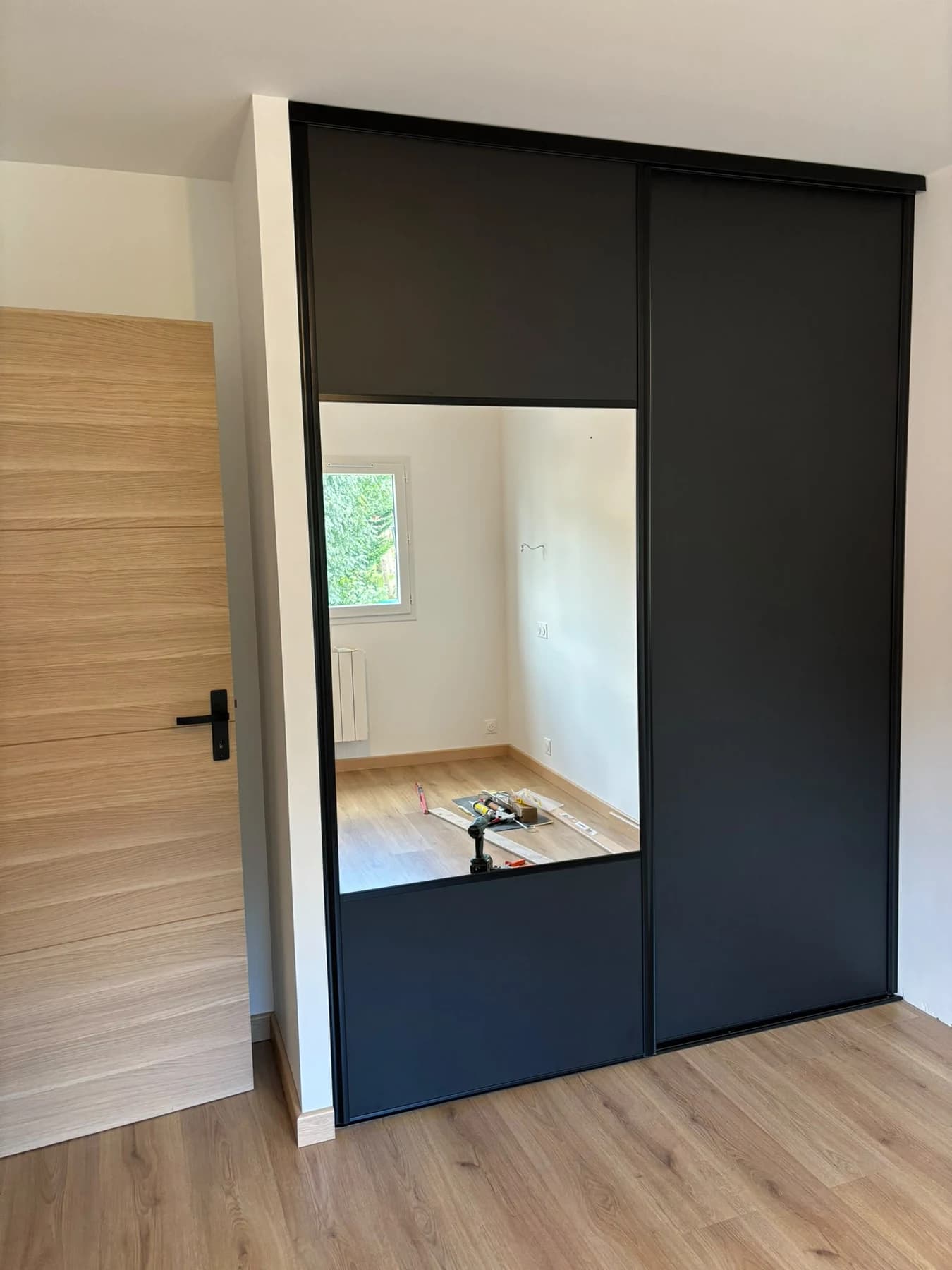 Portes de placard coulissantes sombres avec miroir dans le projet de Soisy-sous-Montmorency.